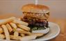 A classic hamburger and fries on a white plate.