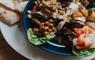 A plate of food with a fresh salad and pita bread, a delicious and healthy meal option.