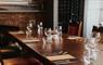 A restaurant table set with empty glasses and place settings, ready for a delicious meal at The Boatshed.