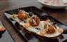 Haggis bon bons set on a rectangle plate sitting on a set table.