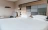 A double bed with white sheets in a Cabarfeidh Hotel, featuring a tweed, check headboard and soft colors.