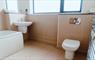 Modern bathroom with sink and toilet in neutral colours.