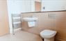 Modern bathroom with sink and toilet in neutral colours.