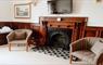 Warm and welcoming room with fireplace and chairs.